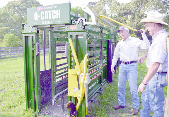 Mr. Selden (left) demonstrates his new cattle chute to Preston Lindsey, director of zone 1 of the Cherokee County Soil &amp; Water Conservation District.