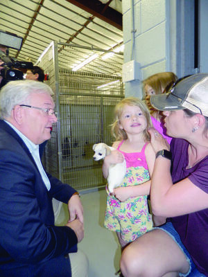 Photo by 
Andrew Lugo


Jacksonville Councilman Randy Gorham visits with fellow residents as they find the perfect furry friend during the grand opening of the Jacksonville Animal Shelter on Monday.