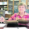 Betty Townsend reviews old ledger books containing handwritten club minutes.