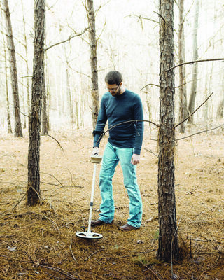 Filmmaker Brackston McKnight uses a metal detector on his property, searching for lost treasure.