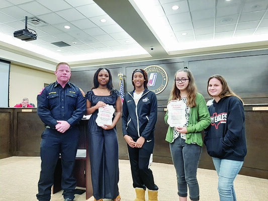 Photo by Michelle Dillon
From left, JFD Chief Keith Fortner poses with JISD students Ta’Kyeria Montgomery and her friend Ladasia Holman; and Olivia Boggs and her cousin Callie Robertson, during the December meeting of the Jacksonville City Council.