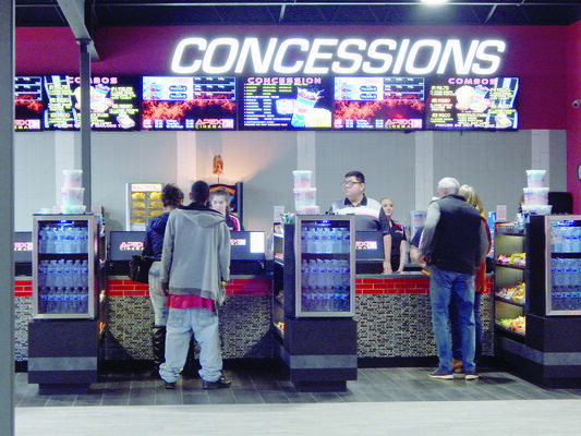 Photo by Michelle Dillon
Local movie-goers check out their options at the newly renovated concessions counter, featured in the new lobby of recently refurbished Apex movie theater in Jacksonville. The theater has reopened for business.