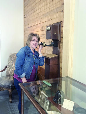 Courtesy Photo
Thursday Study Club President Judy Landrum tries out the vintage telephone on display at the Stella Hill Memorial Library in Alto.