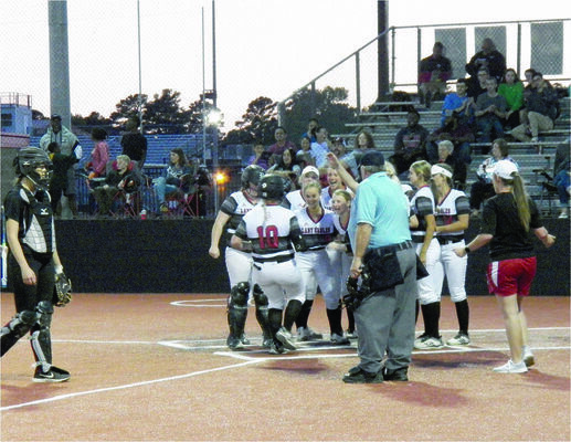 Photo by Michelle Dillon
The team gathers at the plate to welcome "home" Tatum Goff after her homers, with a run batted in, tied the game at five all.