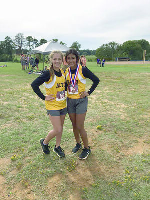 Kylee Powers (left) and Candy Castro of Alto High School participated in district cross country meet on Oct. 16. Castro finished in the top 10 and will advance to Region III Championships.