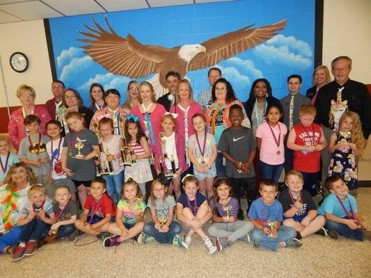 Students pose with  members of the community modeling their ties after receiving awards for the Tacky Tie Contest