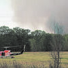 Black smoke curls behind a tree line as a Texas Forest Service helicopter crew sets down.  The crew met with volunteers from the Douglass and Alto Fire Departments, as well as the Cherokee County Sheriff's Department.